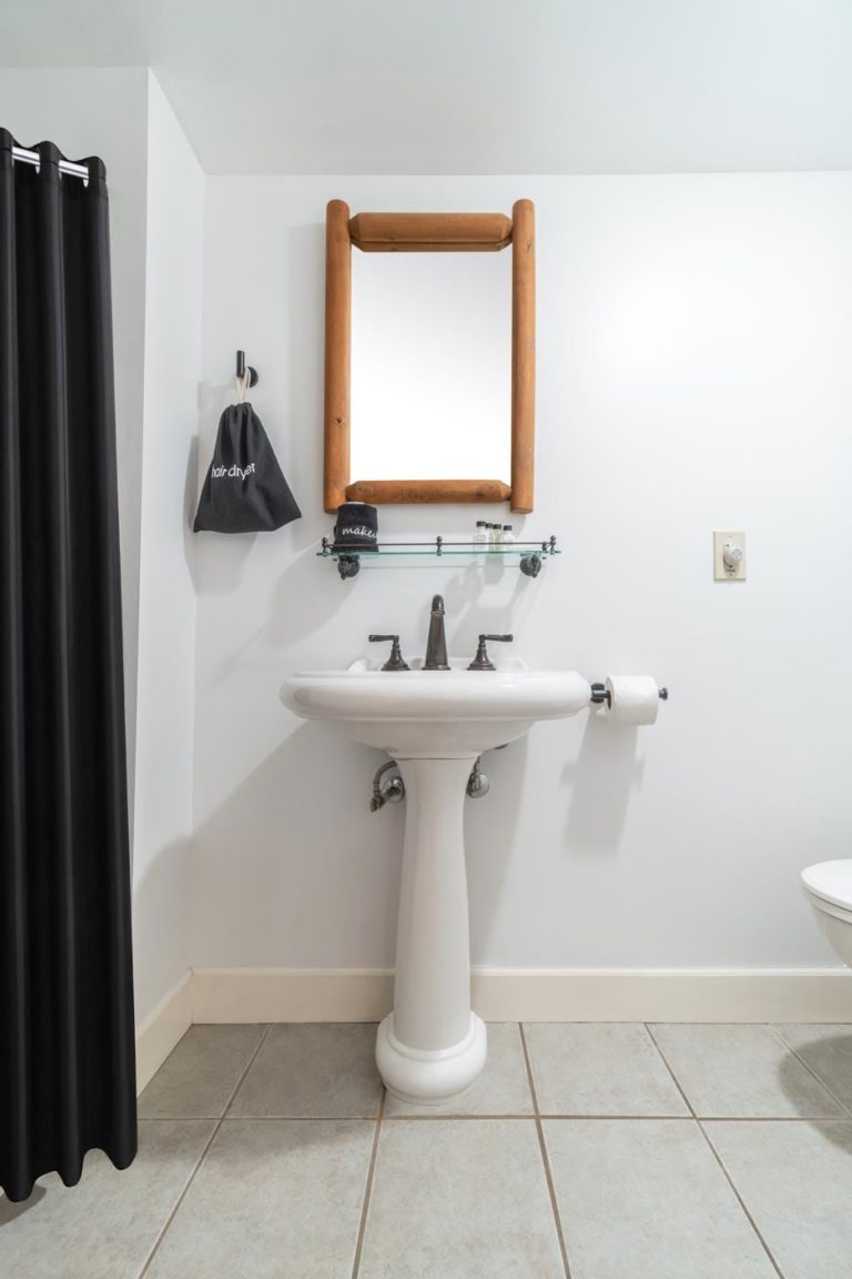 a bathroom with a pedestal sink and a mirror