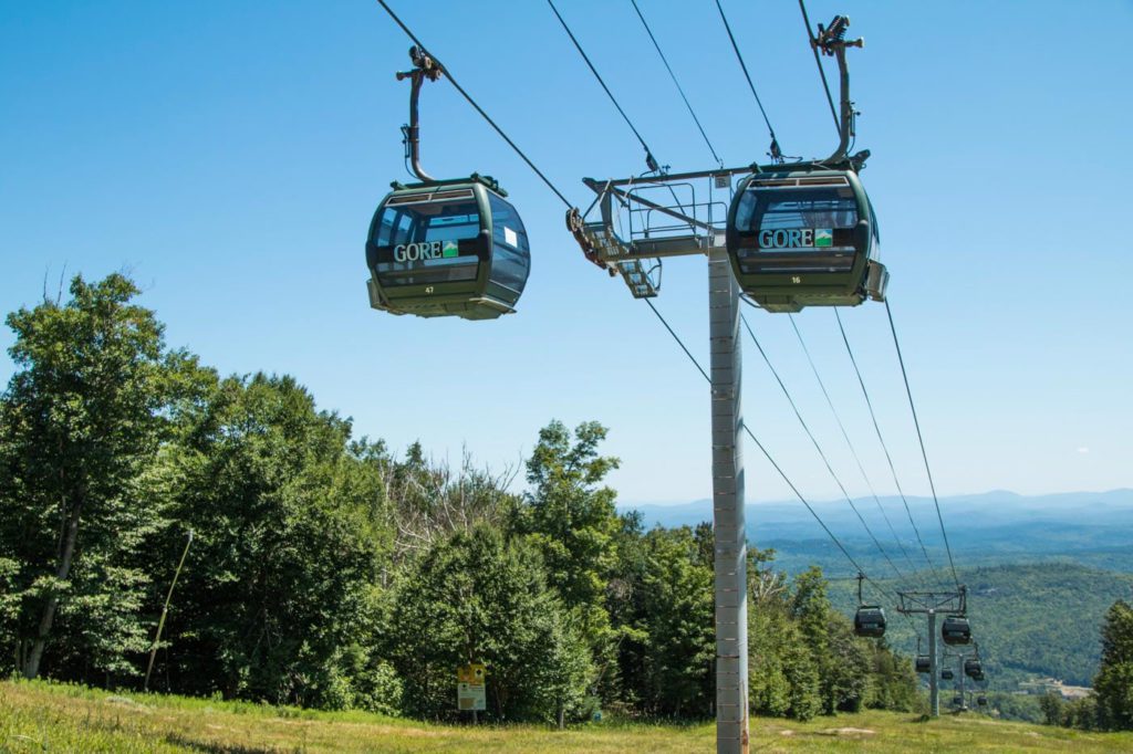 a couple of gondolas that are above a hill