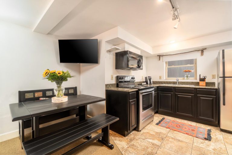 a kitchen with black cabinets and stainless steel appliances