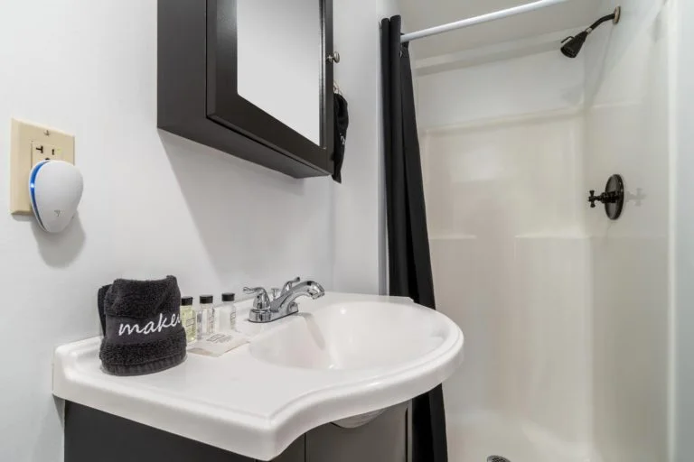 a bathroom with a sink, mirror, and shower