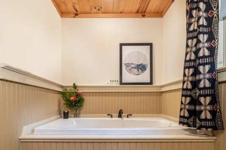 a bathroom with a bathtub and a picture on the wall