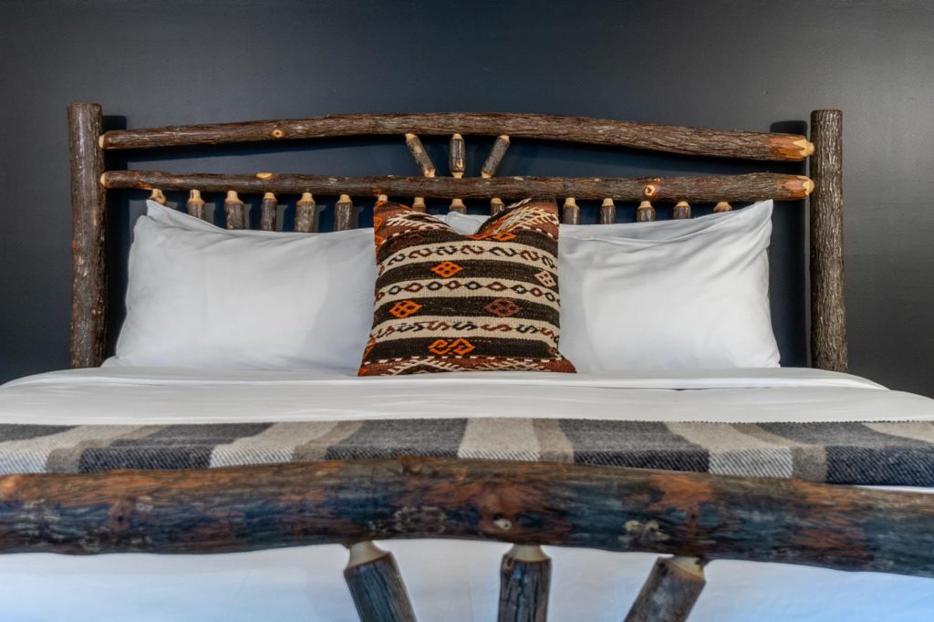 a bed with a wooden headboard and white pillows