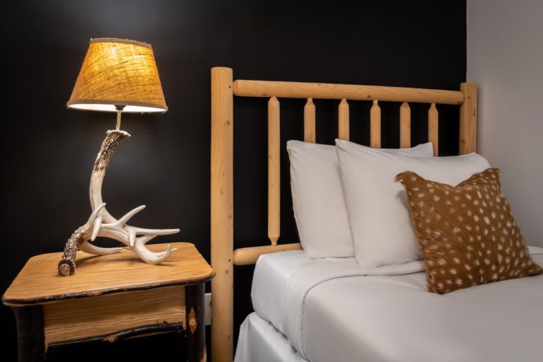 a bed with a wooden headboard and a night stand with a lamp on it