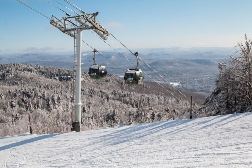 a ski lift with two skiers going up a hill