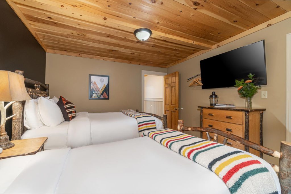 a hotel room with two beds and a flat screen tv
