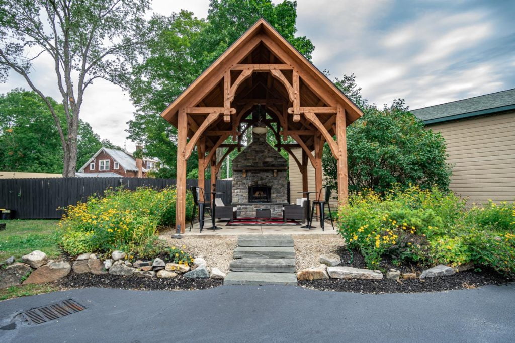 a gazebo with a fire place in the middle of a yard