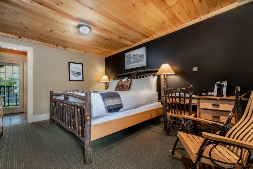 a bed sitting in a hotel room next to a wooden table