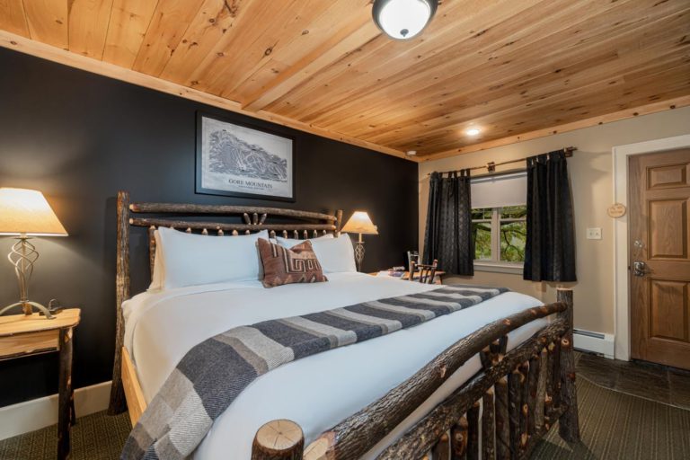 a hotel room with a large bed and a wooden ceiling