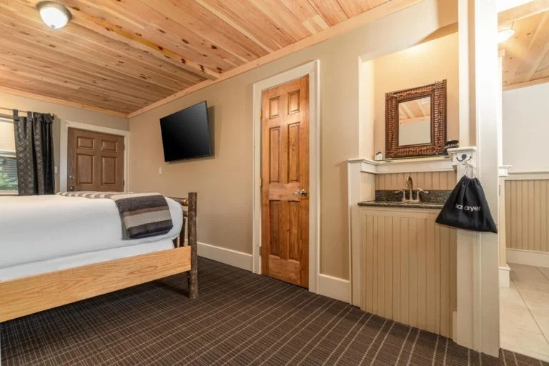 a hotel room with a bed and a tv mounted on the wall