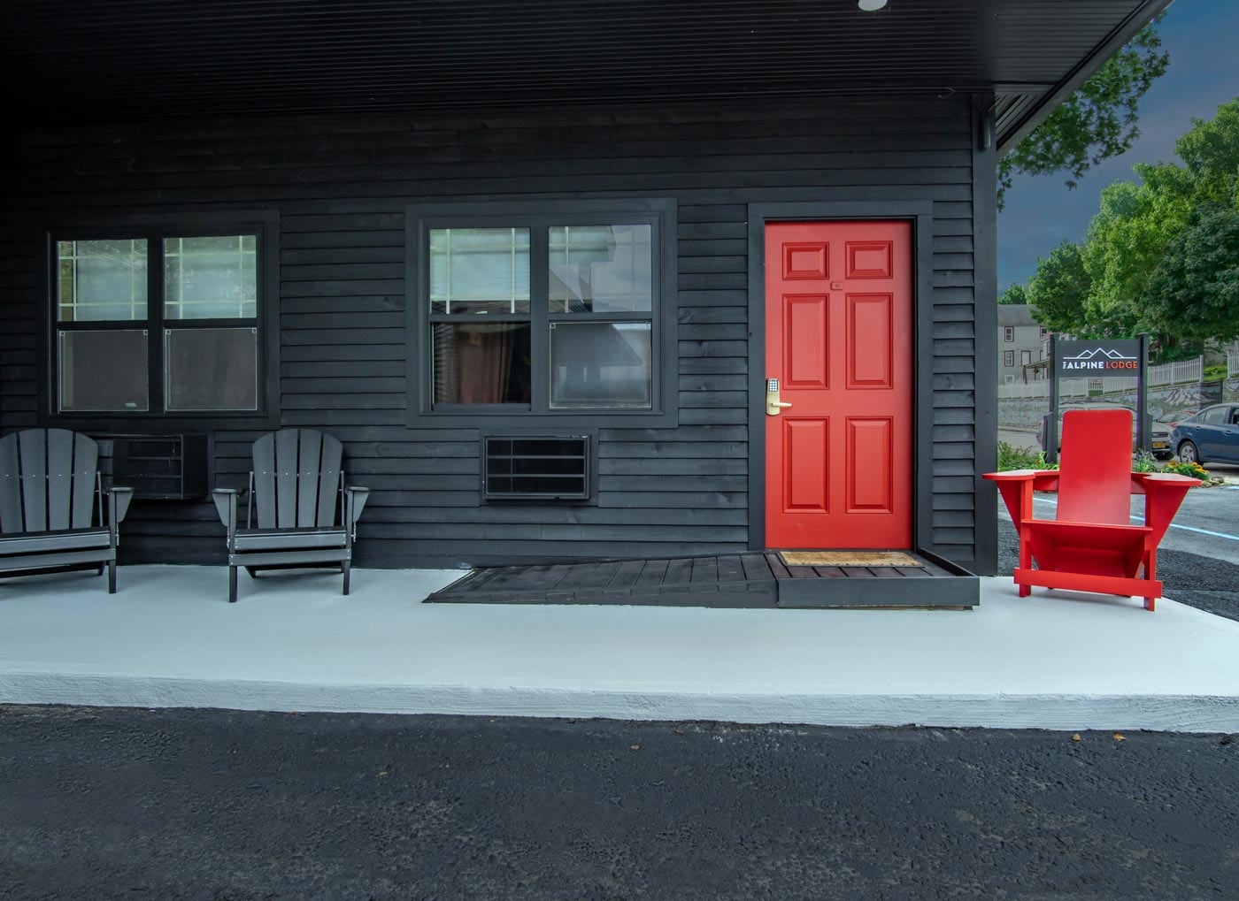a red door and two chairs on a porch