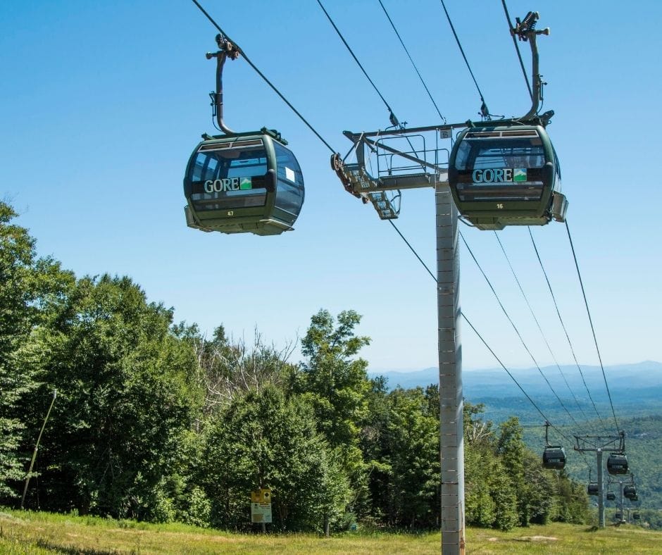 a couple of gondolas that are above a hill