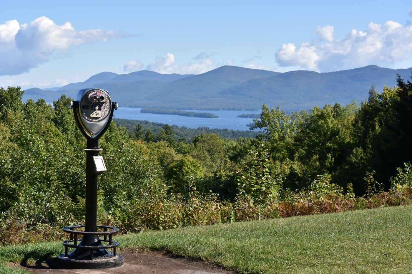a parking meter on a hill overlooking a lake