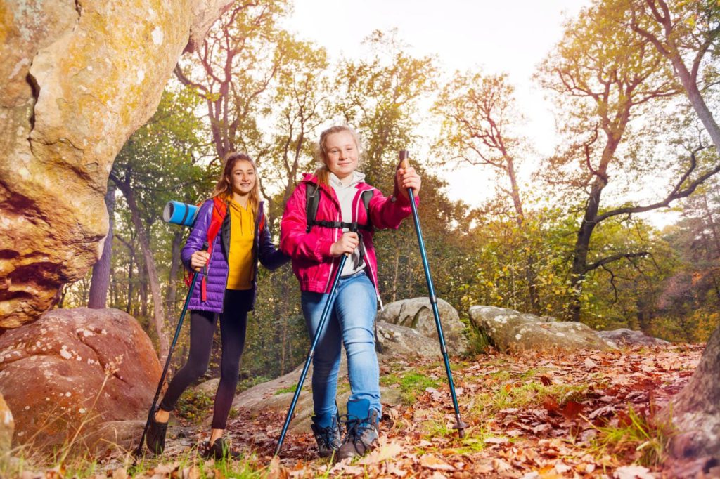 a couple of women standing next to each other on top of a forest