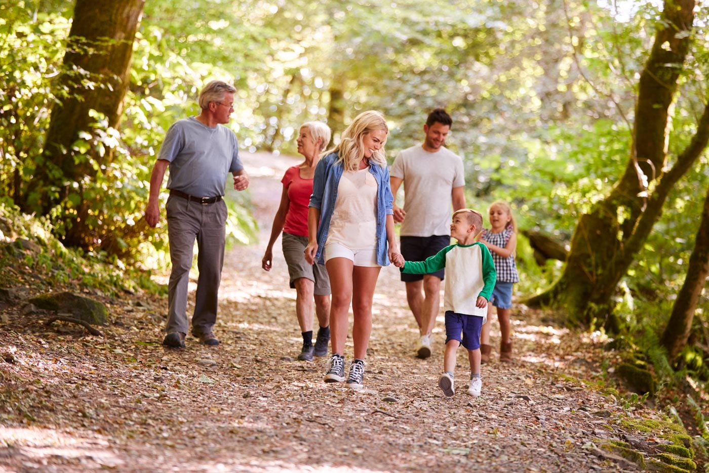 a family walking down a path in the woods